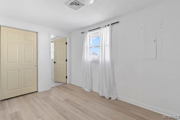 unfurnished bedroom featuring light wood-style flooring, baseboards, and visible vents