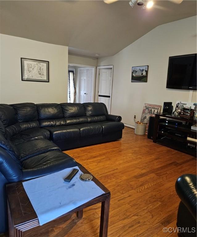 living area with lofted ceiling and wood finished floors