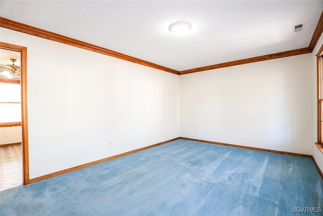 carpeted empty room featuring crown molding, baseboards, and visible vents