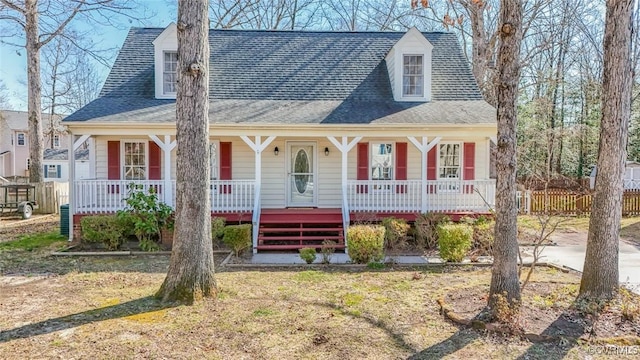 view of front of home featuring a porch, fence, and roof with shingles