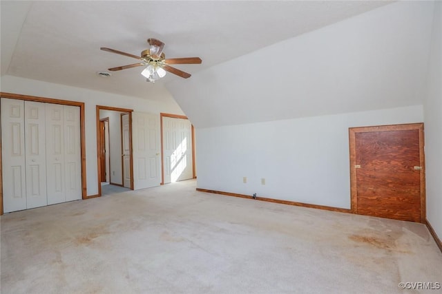 bonus room with vaulted ceiling, carpet flooring, a ceiling fan, and baseboards