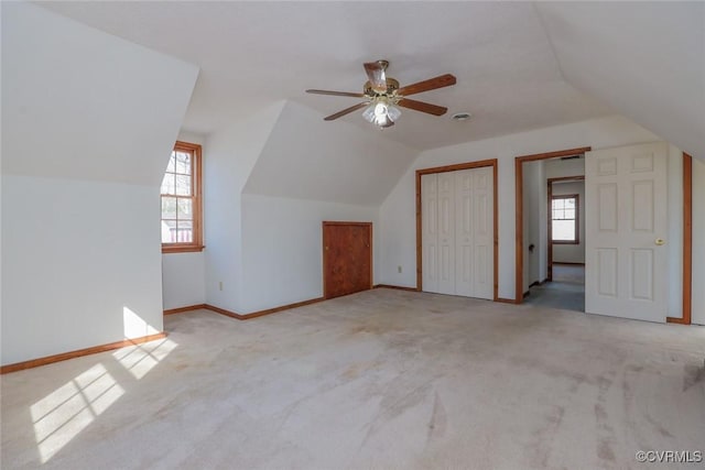 additional living space with carpet flooring, a ceiling fan, baseboards, and vaulted ceiling