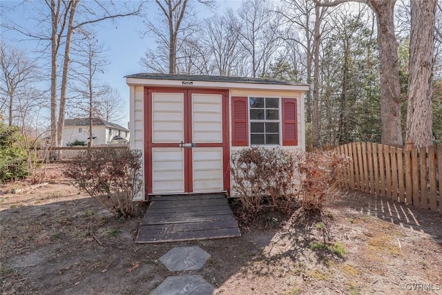 view of shed featuring fence