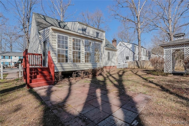 back of house with a patio area, fence, and roof with shingles