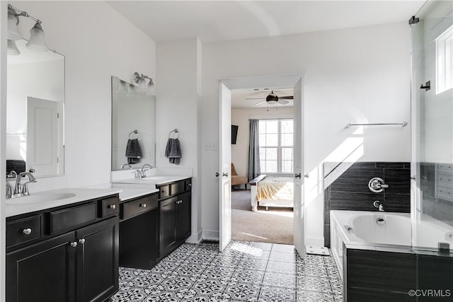 ensuite bathroom with a tub to relax in, ensuite bathroom, a ceiling fan, tile patterned flooring, and vanity