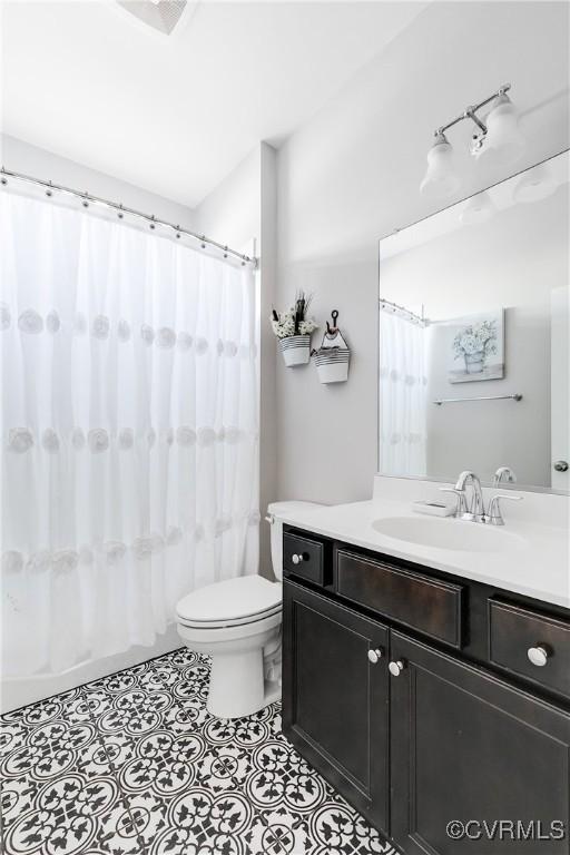 bathroom featuring tile patterned floors, toilet, and vanity