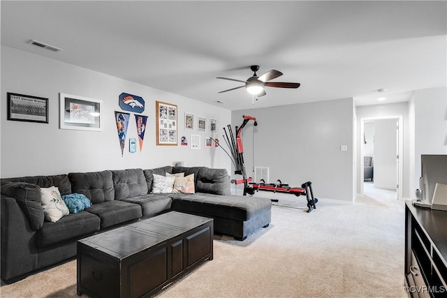 living area with visible vents, light colored carpet, baseboards, and a ceiling fan