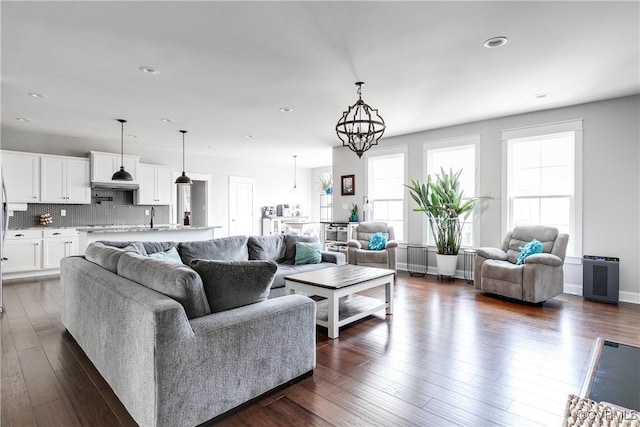 living area with recessed lighting, baseboards, a chandelier, and dark wood-style flooring