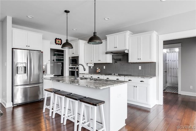 kitchen featuring decorative backsplash, dark wood-style floors, appliances with stainless steel finishes, and a sink