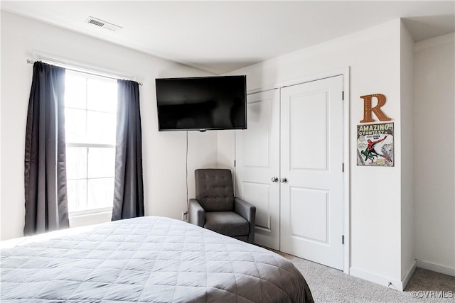 bedroom with baseboards, visible vents, carpet floors, and a closet