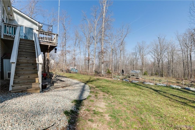 view of yard with stairway, a wooden deck, and fence