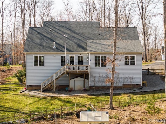 back of house with a storage unit, an outbuilding, fence, a yard, and stairs