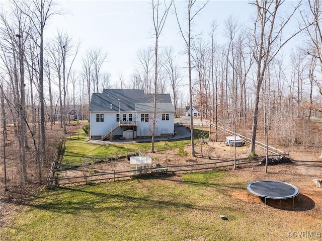 view of yard featuring a trampoline and fence