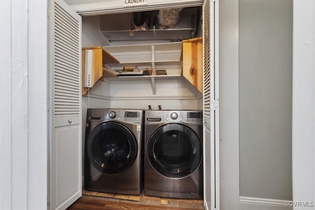 washroom featuring cabinet space, washing machine and dryer, and wood finished floors