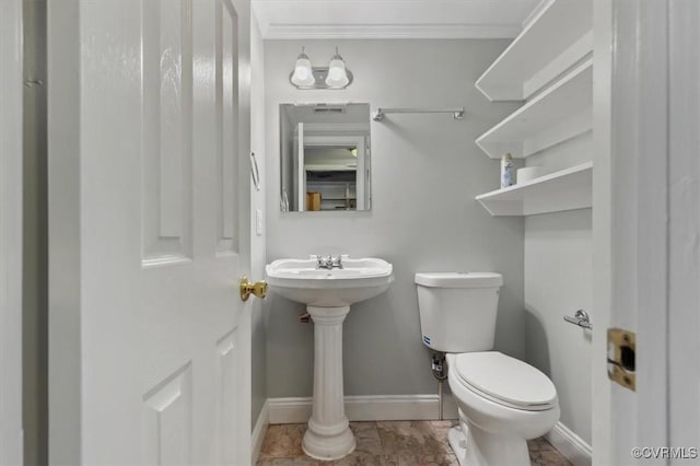 half bathroom featuring baseboards, toilet, and ornamental molding