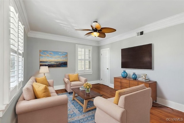 living room with visible vents, crown molding, baseboards, and wood finished floors