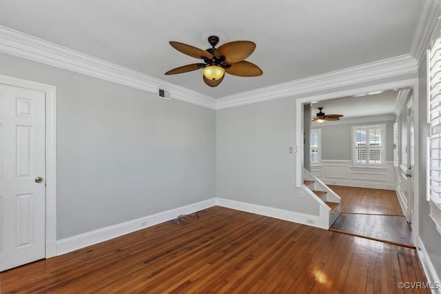 spare room featuring visible vents, crown molding, ceiling fan, stairway, and hardwood / wood-style flooring