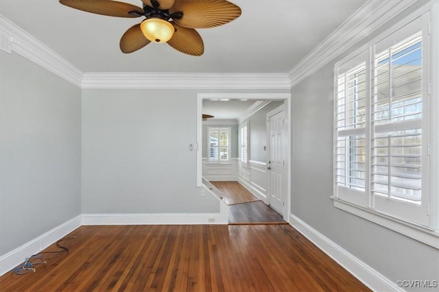 spare room featuring crown molding, baseboards, and wood-type flooring