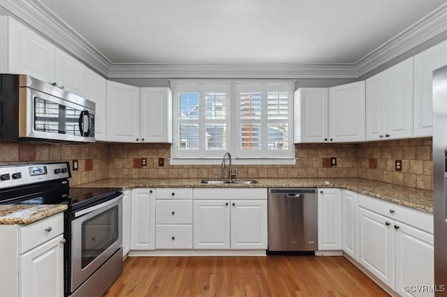 kitchen featuring a sink, stainless steel appliances, light wood-style flooring, and white cabinets