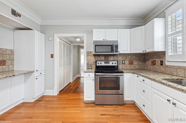 kitchen with light wood-type flooring, backsplash, white cabinetry, stainless steel appliances, and crown molding