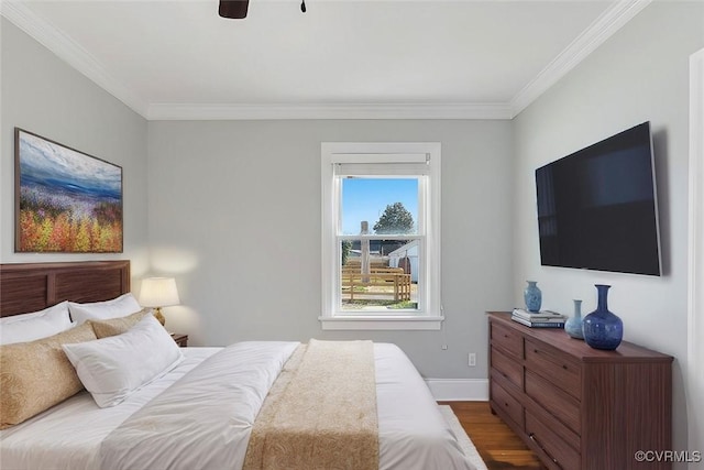 bedroom featuring ceiling fan, baseboards, wood finished floors, and crown molding