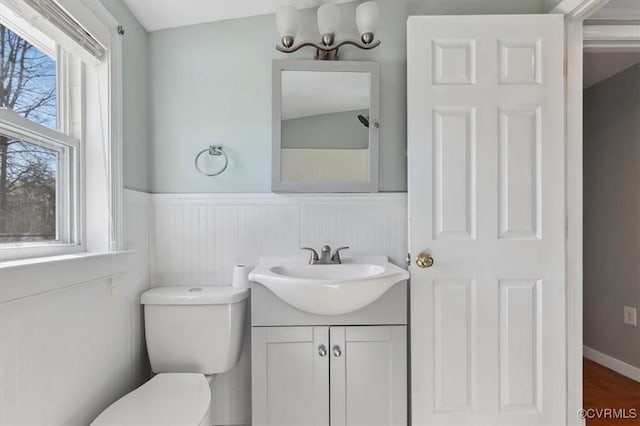 bathroom featuring wainscoting, toilet, and vanity