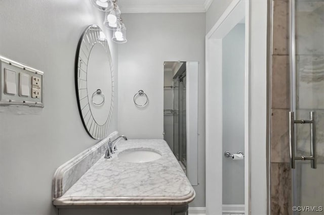 full bath with ornamental molding, a stall shower, and a sink