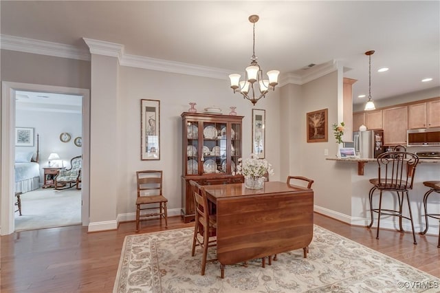 dining space featuring a notable chandelier, wood finished floors, and crown molding