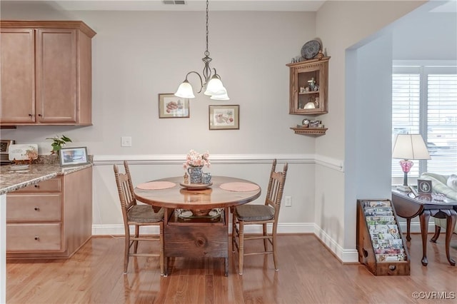 dining area featuring a chandelier, visible vents, baseboards, and light wood-style floors