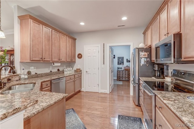 kitchen with light stone counters, visible vents, appliances with stainless steel finishes, and a sink