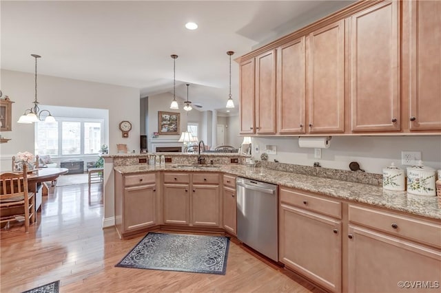 kitchen featuring light wood-type flooring, light brown cabinets, a sink, stainless steel dishwasher, and a peninsula