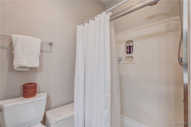 bathroom featuring curtained shower and toilet