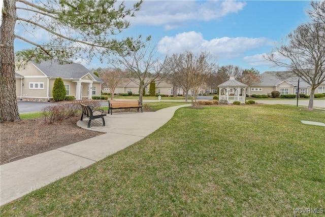 surrounding community with a gazebo, a residential view, and a yard