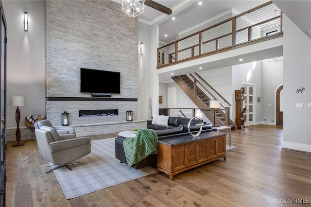 living room featuring light wood-style flooring, a fireplace, arched walkways, and baseboards