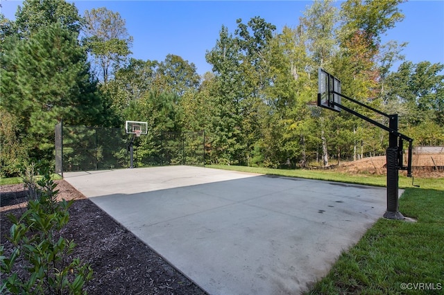 view of basketball court with basketball court and a yard