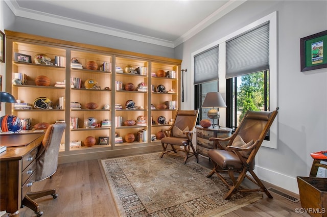 living area with crown molding, wood finished floors, visible vents, and baseboards