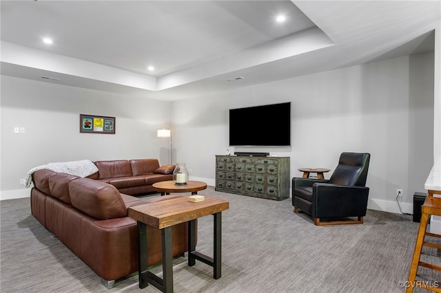 carpeted living room featuring a tray ceiling, recessed lighting, and baseboards