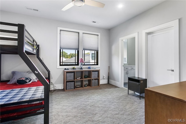 carpeted bedroom with visible vents, ceiling fan, ensuite bath, and baseboards