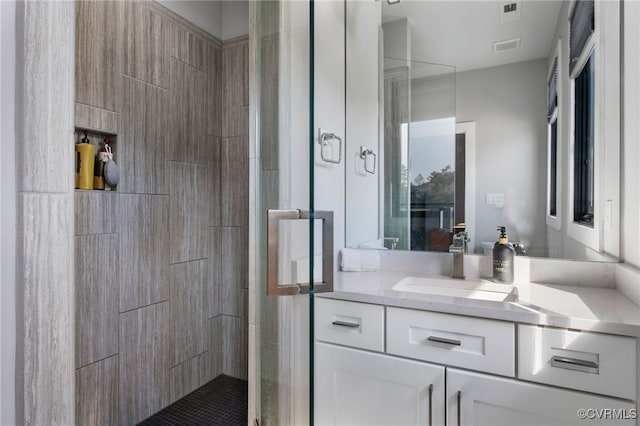 bathroom featuring visible vents, a stall shower, and vanity