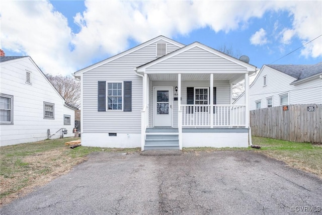 bungalow-style home featuring a porch, fence, and crawl space