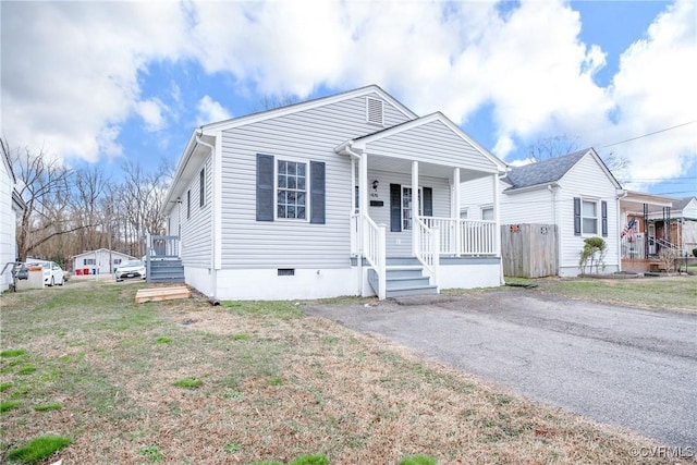 view of front of property featuring crawl space, a porch, driveway, and a front yard