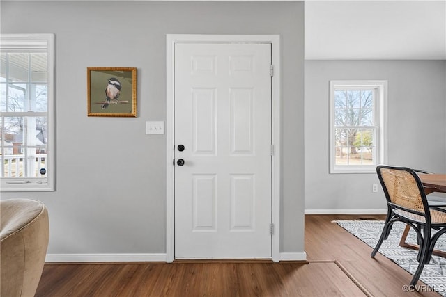 foyer entrance with wood finished floors and baseboards