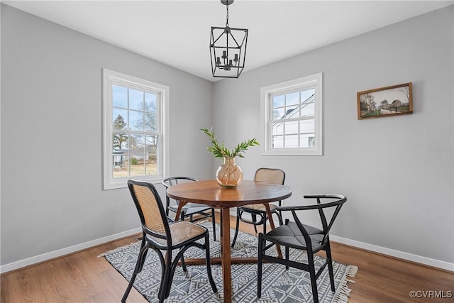 dining space with a wealth of natural light, baseboards, and wood finished floors