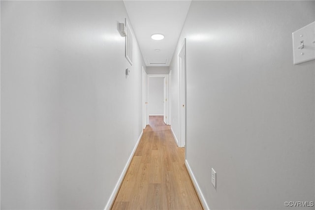 hall with baseboards and light wood-style flooring