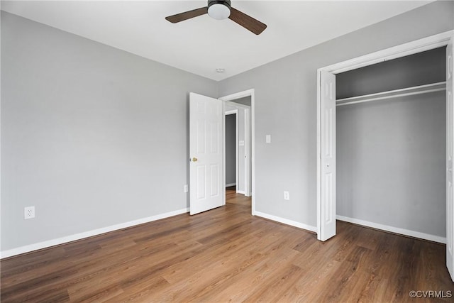 unfurnished bedroom featuring a ceiling fan, wood finished floors, baseboards, and a closet