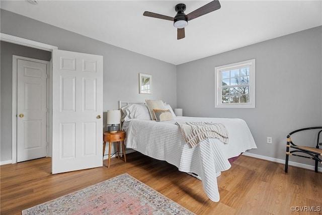 bedroom featuring wood finished floors, baseboards, and ceiling fan