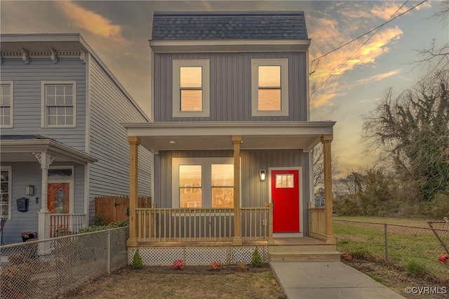 view of front of home featuring a porch, a shingled roof, board and batten siding, and fence