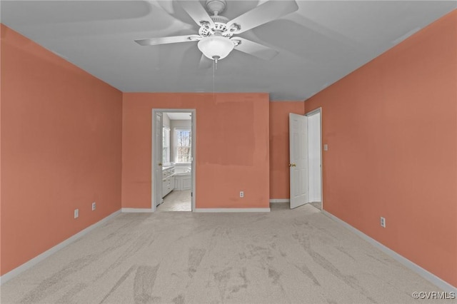 empty room with light carpet, a ceiling fan, and baseboards