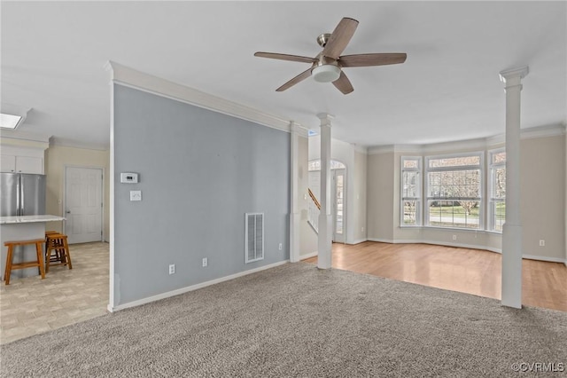 unfurnished living room featuring visible vents, crown molding, light colored carpet, ornate columns, and a ceiling fan