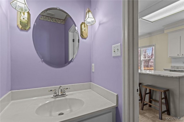 bathroom with ornamental molding and vanity